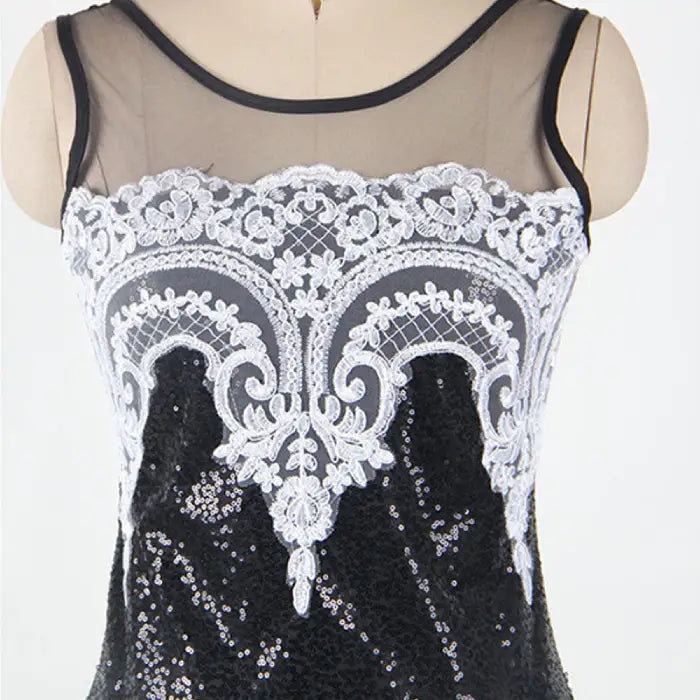 Close-up image highlighting the intricate white lace appliqué and sparkling texture on the black sequin mermaid dress.