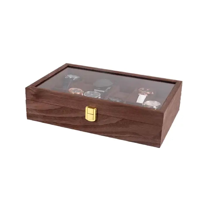 Closed wooden watch box with a gold latch and a glass display top showing assorted watches inside