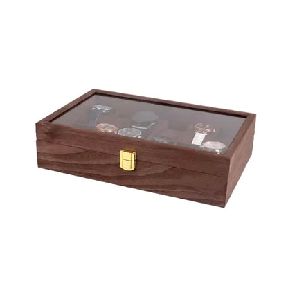 Closed wooden watch box with a gold latch and a glass display top showing assorted watches inside