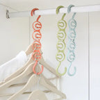 Closet organizer hanger displaying clothes on coral green and blue chain hooks