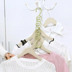 Closet organizer hanger in green holding layered clothing on wooden hangers