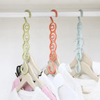 Closet organizer hanger holding multiple clothes on pastel chain hooks