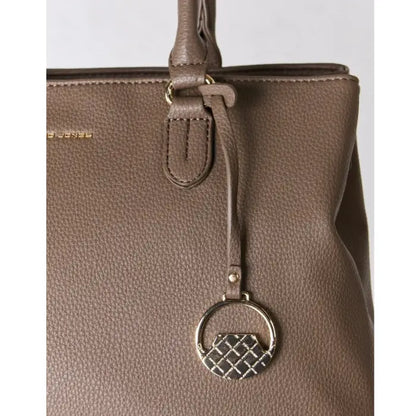 Closeup of a brown tote bag with detailed golden charm.