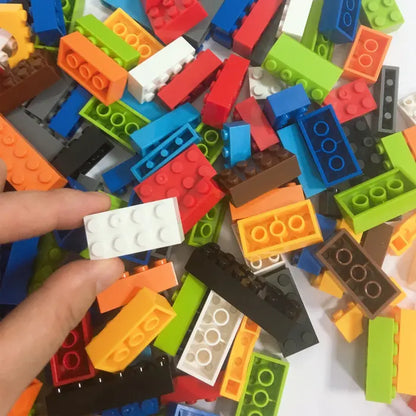 Close-up view of colorful building bricks, including a white brick held between fingers.