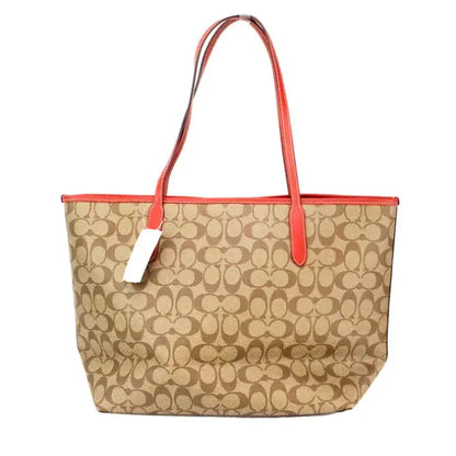 Back view of Coach tote bag with signature monogram print and vibrant red trim.