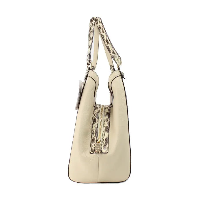 Side profile of Coach tote bag in beige with snake print trim and gold zipper details.