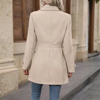 Coat Buttons back view of beige belted coat with long sleeves.