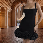 cocktail dress in classic black with square neckline and structured ruffle hem photographed in luxurious architectural venue with arched ceiling