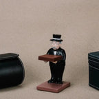 collector watch display figurine placed between two watch cases, highlighting its decorative and practical use.