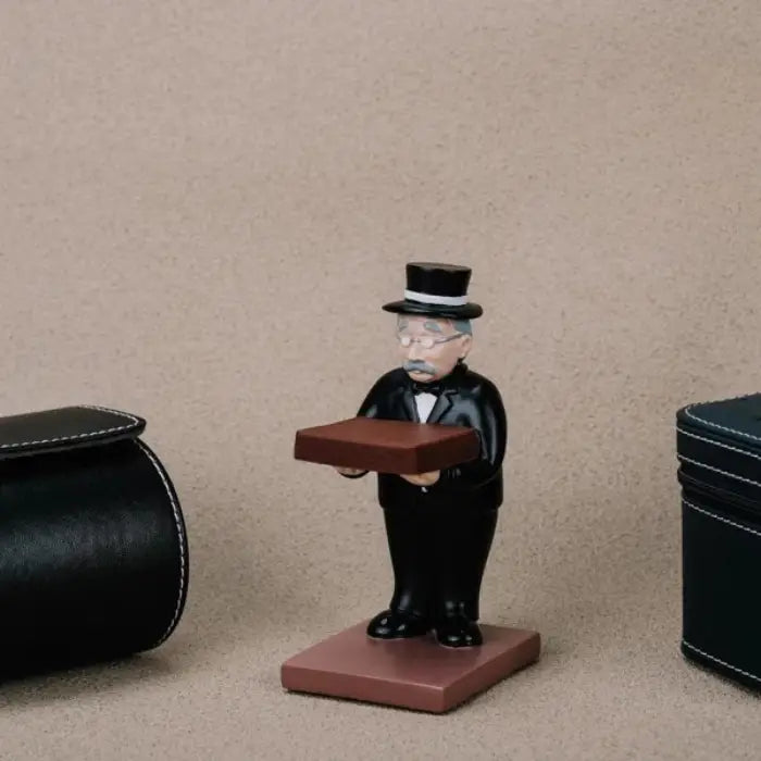 collector watch display figurine placed between two watch cases, highlighting its decorative and practical use.