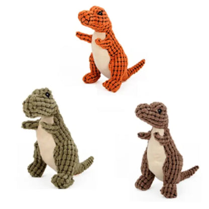 A set of three plush dinosaur toys in green, orange, and brown with textured designs.