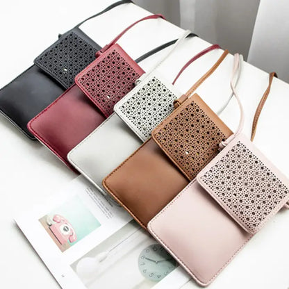 A variety of leather crossbody phone bags with perforated designs in multiple colors displayed on a table.