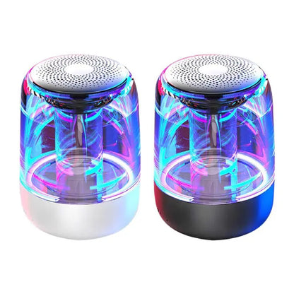  Wireless speakers with transparent bodies, neon blue and pink lights, and perforated silver tops on white and black bases