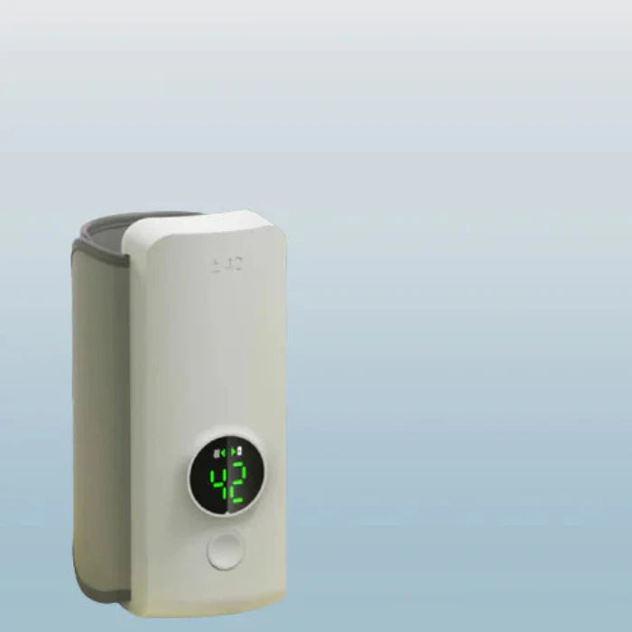 Compact white bottle warmer with green digital display showing 42 degrees, against light blue gradient background