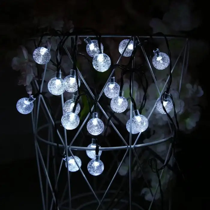 Cool white crystal ball lights strung on geometric metal structure, providing elegant illumination for modern decor