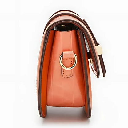 Side profile of structured coral bag featuring gold D-ring hardware and contrasting leather trim details