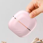 Cordless hair straightener in light pink color shown in hand for portable, travel-friendly use.