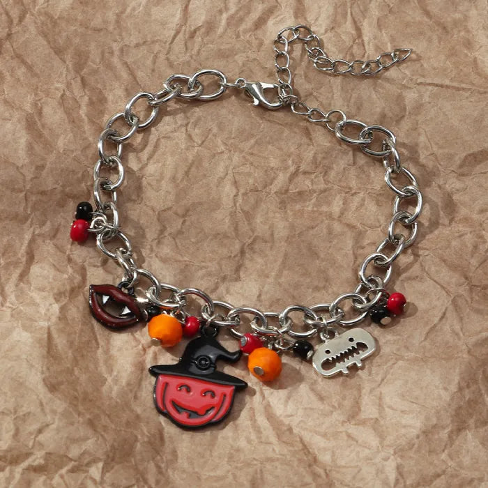 Halloween costume jewelry bracelet with vampire lips and pumpkin charms on crumpled paper background.