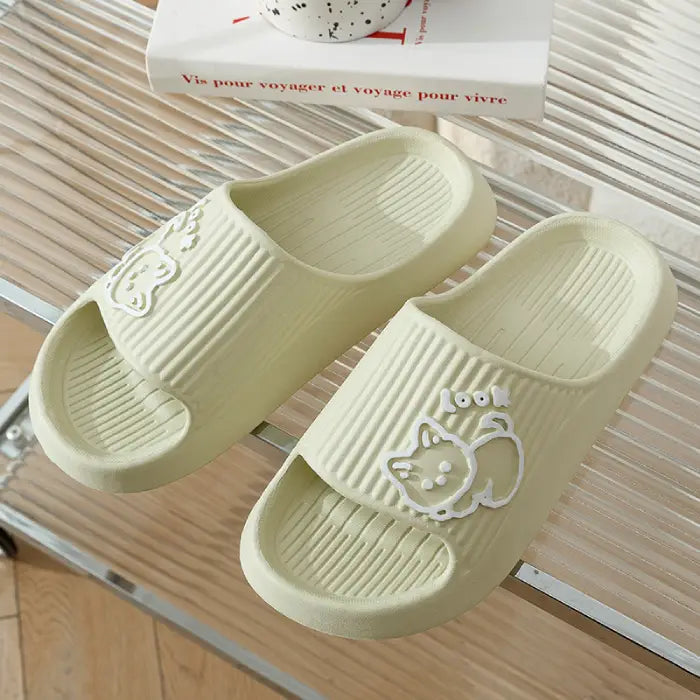 Cream-colored bathroom slides with embossed cat design shown on textured surface