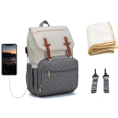 Two-tone diaper backpack in cream and grey with brown leather straps and quilted pocket for versatile storage options