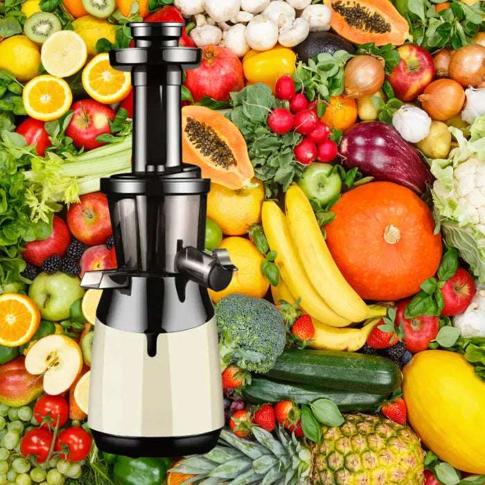 Slow masticating juicer in cream color with fresh tropical fruits and organic vegetables for healthy juice making
