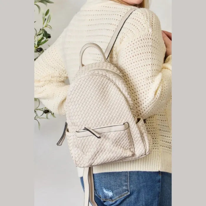 Cream woven leather backpack worn by a woman in casual outfit, perfect for stylish daily use.