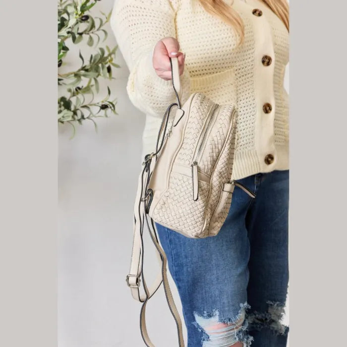 Side view of a cream woven leather backpack with adjustable straps and modern detailing.