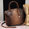 Crocodile embossed handbag in rich brown with polished finish and dual handles, styled for elegance.