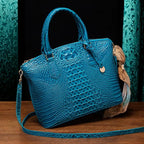 Crocodile embossed handbag in vibrant teal with sleek silhouette and gold charm against elegant decor.