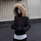 Cropped bomber jacket with fur hood shown in side profile, winter puffer silhouette emphasizing warmth and relaxed fit