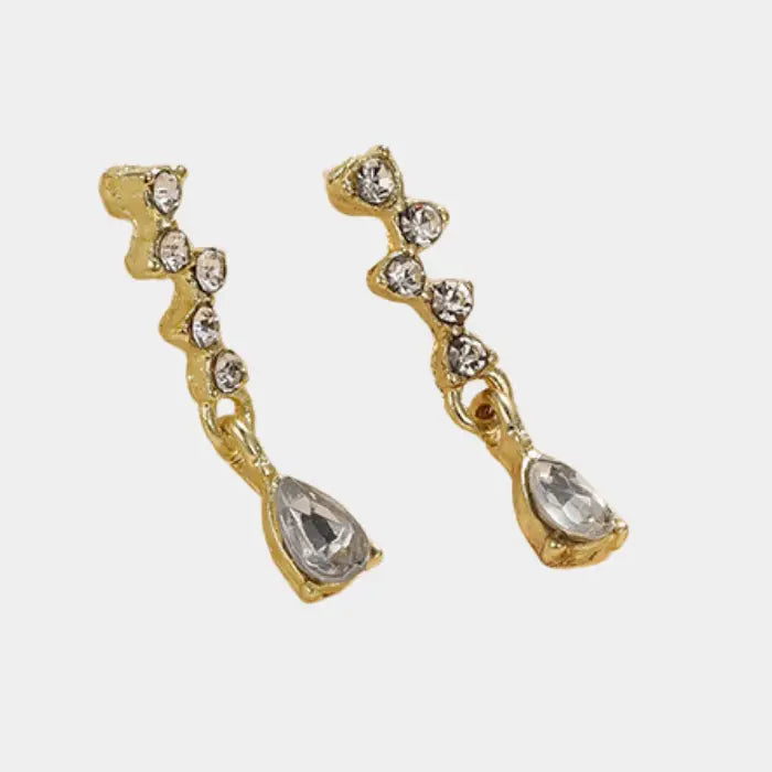 crystal teardrop dangle earrings in gold isolated on white, shimmering rhinestone accents ideal for chic lightweight jewelry collections