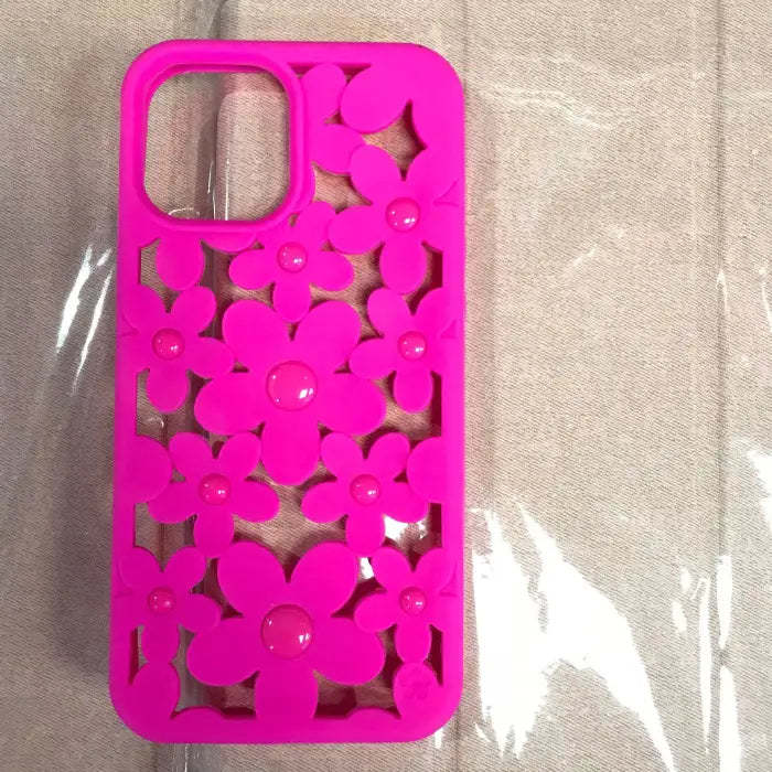 Cute floral iPhone case in vibrant hot pink color with daisy flower cutout pattern and glossy button centers