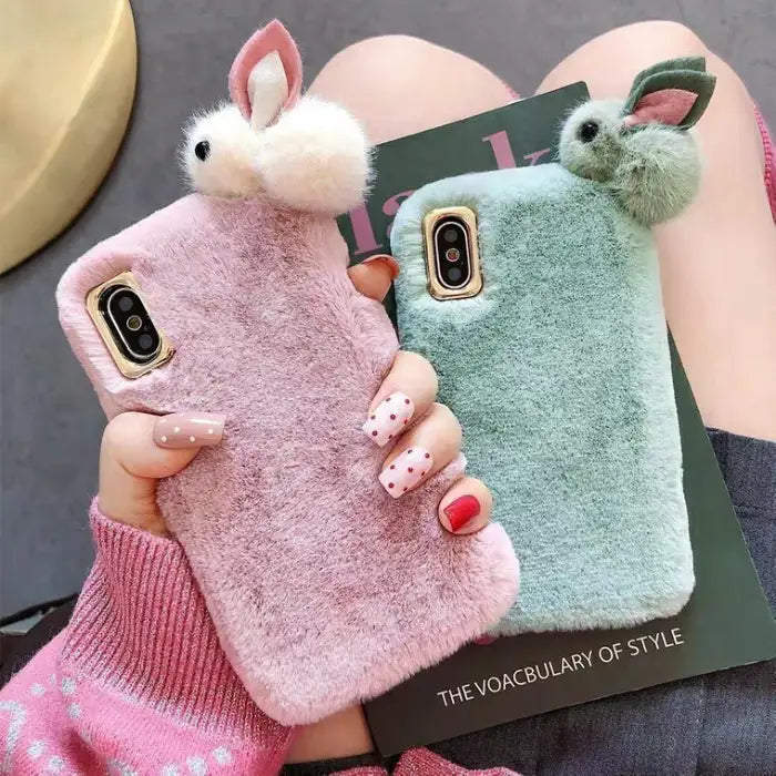 set of cute fluffy iPhone cases in pink and mint green with plush material and bunny ear accents.