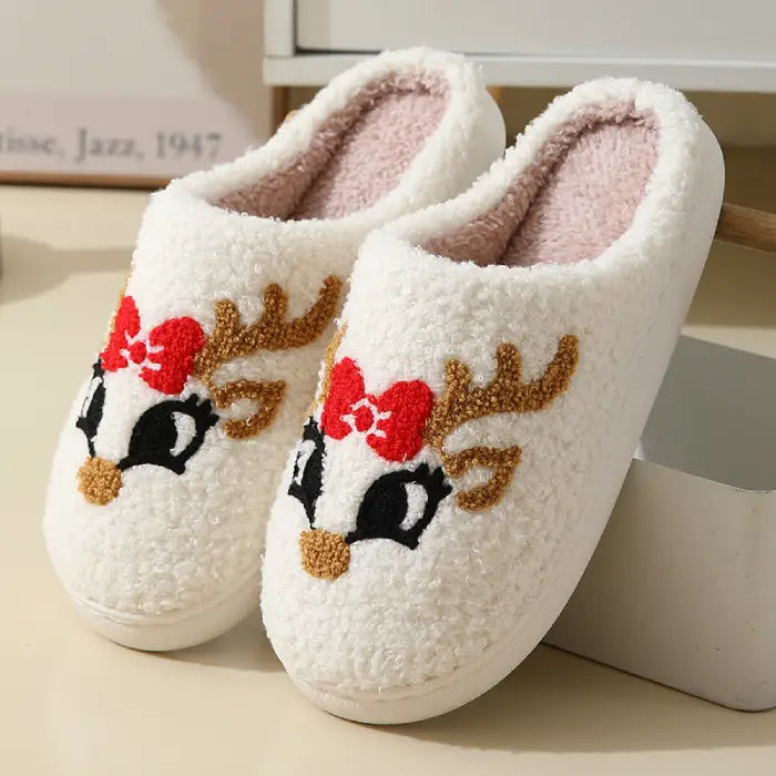 Cute Christmas slippers with reindeer faces and red bows, perfect for the holidays.