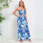 Cute summer dress with blue tropical leaf pattern on white background, featuring v-neck and flowing maxi silhouette