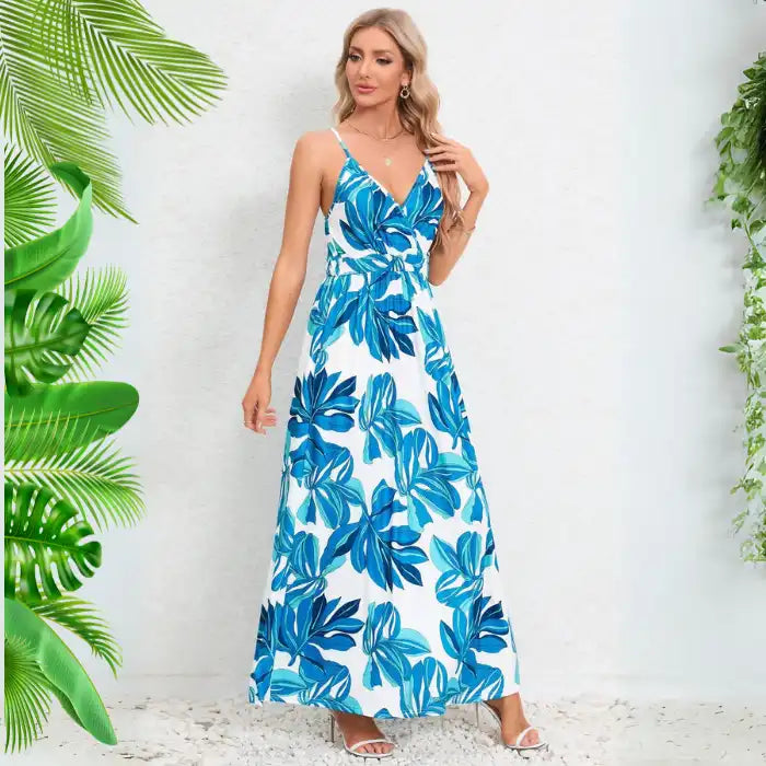 Cute summer dress in white with blue leaf pattern featuring v-neck wrap design and thin straps for stylish hot weather wear