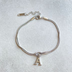 Silver bracelet with a letter 'A' charm on a light gray background