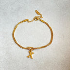 Gold bracelet with a unique charm on a light gray background