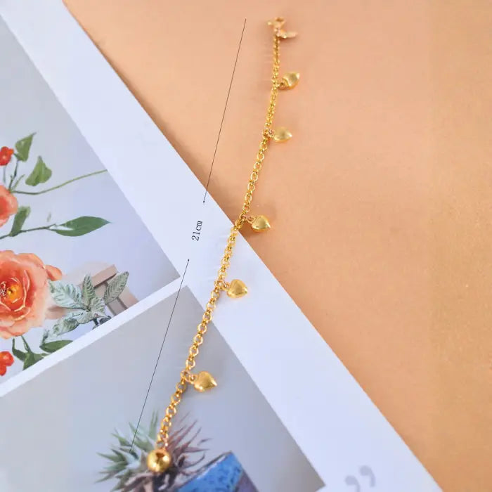 dainty gold heart chain bracelet shown extended with measurement detail, featuring multiple heart charms for a delicate minimalist look