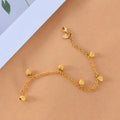 dainty gold heart chain bracelet arranged on warm background with dangling charms, highlighting an elegant minimalist jewelry style