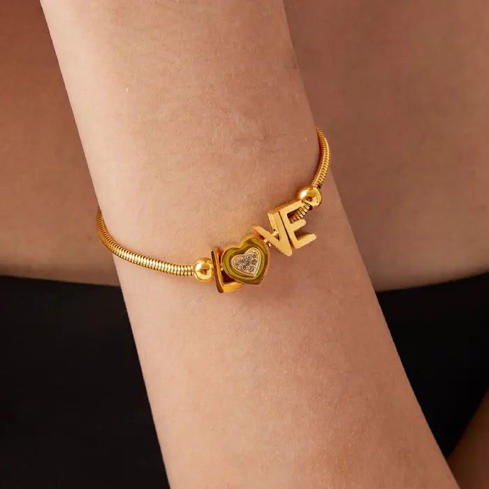 Styled shot of delicate gold LOVE bracelet on arm showing proportions and fit