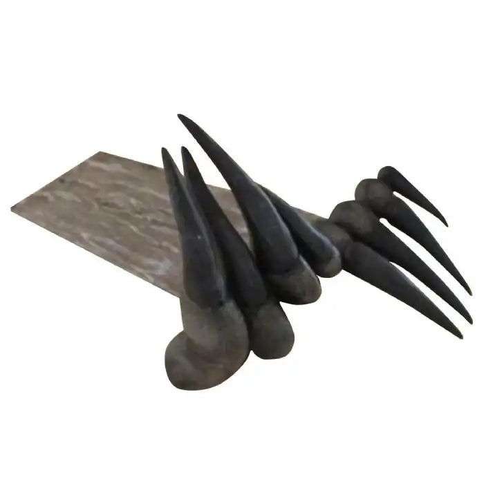 Decorative sculpture of dinosaur claw-shaped bookmark with dark spikes on a wood-textured base.