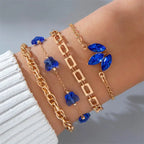Delicate gold bracelets featuring blue gemstones with floral and geometric designs for elegant styling.