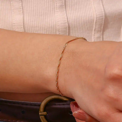 Closeup of a delicate gold rope chain bracelet on a wrist, perfect for subtle and sophisticated styling.