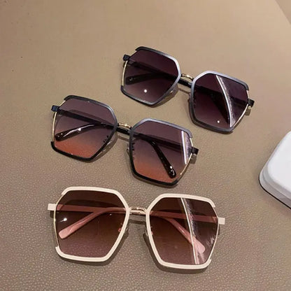 Collection of three hexagonal designer sunglasses in white, gray and black frames with gradient lenses