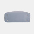  Bottom view of grey leather tote showing protective metal feet and structured base