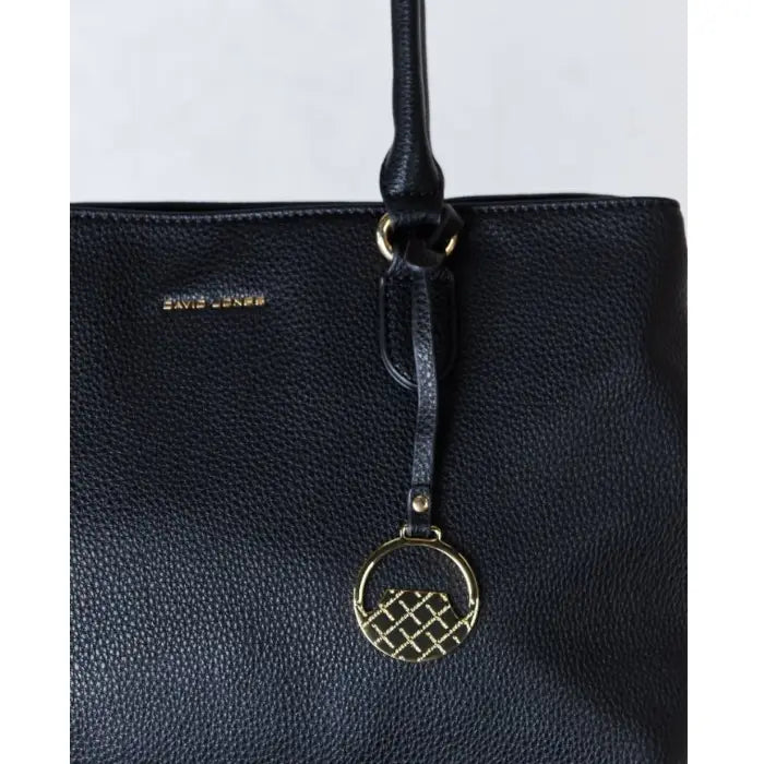  Detailed view of a black leather handbag's logo and charm.