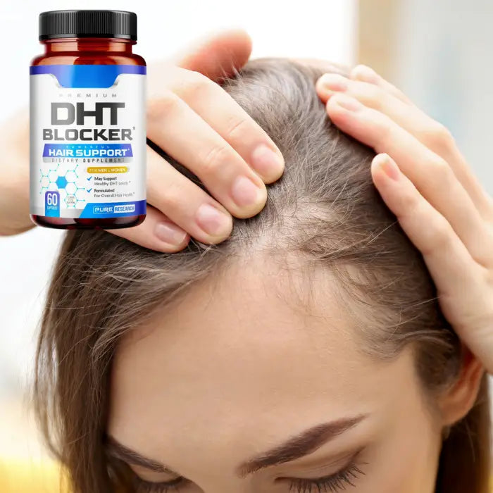 Woman examining thinning hair with a DHT Blocker hair support supplement bottle in view.