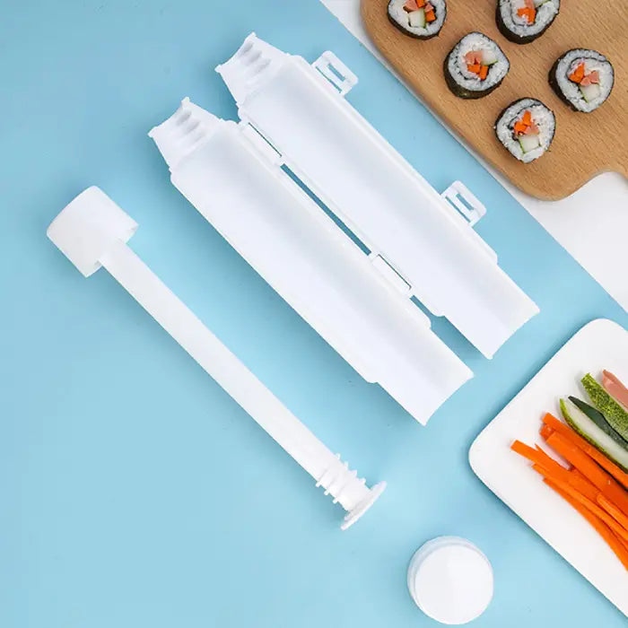 DIY sushi roller kit disassembled on a blue background, with sushi rolls, sliced vegetables, and a rolling mold.