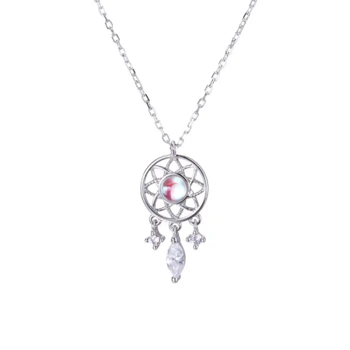 Silver dreamcatcher pendant necklace with luminous gemstone and dangling crystal charms on white background.